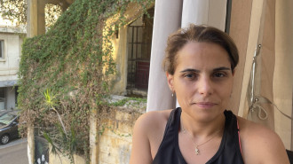 Mirna Habbouche, a 39-year old accountant, stands on her balcony in the Karantina neighbourhood of Beirut. [William Christou - TNA]