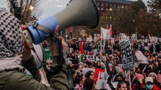 Protester leads chant while others sit in front of the White House during national march for Palestine in Washington, DC on 4 November. [Laura Albast for The New Arab]