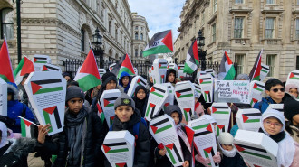 Children carrying makeshift coffins and Palestinian flags in a vigil