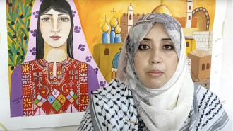 Woman in front of a painting of a Palestinian woman and buildings