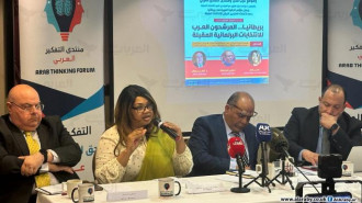 Three men and a woman sat at a table in a panel discussion