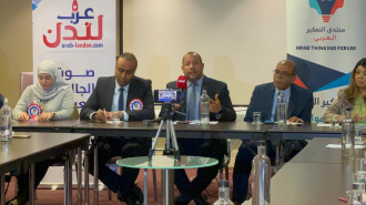 A panel with five people sat behind a table 