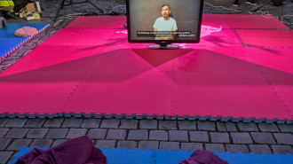 Pink mat with a screen on it with a man in a white t-shirt on the screen