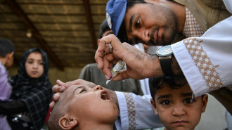  An Afghan health worker administers polio vaccine drops to a child during a polio vaccination campaign in Kandahar on July 8, 2024. 