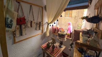 A woman walks in front of a shop selling traditional items in the Old City of Tripoli on September 11, 2024. [Getty]