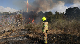 A first responder puts out a fire in an open in Lod near Tel Aviv, reportedly caused by a missile fired from Yemen on September 15, 2024.