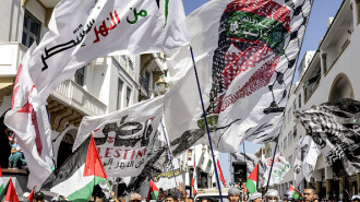 A Moroccan protestor holds a flag depicting Hamas' military spokesman Abu Obaida during a rally in solidarity with Palestinians in Morocco's capital Rabat on October 6, 2024