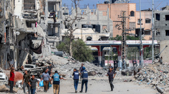 Journalists film while standing before destroyed buildings in the Jabalia camp for Palestinian refugees in the northern Gaza Strip on October 9, 2024