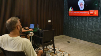 People follow at a cafe in Beirut a televised speech by Hezbollah deputy chief, Naim Qassem