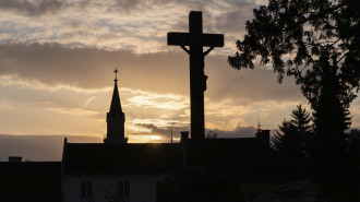 Sunset, silhouette of a cross and a church tower, Jakobifriedhof, Le