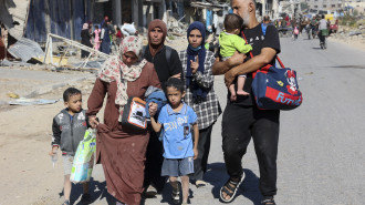 Displaced Palestinians fleeing Israeli military operations in Beit Lahia in the northern Gaza strip walk along the Salah al-Din main road in eastern Gaza City