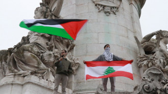  demonstrator waving a Palestinian flag and a demonstrator unfurling a Lebanese flag are seen as hundreds of demonstrators gather with banners and flags on the International Day to End Impunity for Crimes against Journalists to condemn the targeting of journalists, especially in conflict zones such as Gaza and Lebanon in Paris, France on November 02, 2024.