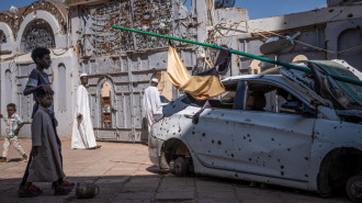 People walk across the courtyard of a war-torn mosque in Omdourman, Sudan