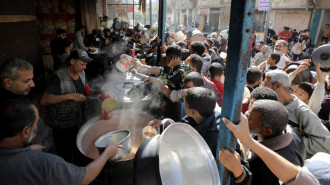 Palestinians, including children, living in the Nuseirat refugee camp wait with empty pots to receive food distributed by an aid organization as they are unable to meet many vital needs, including basic food supplies, in Gaza City, Gaza on November 08, 2024. 