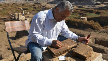 Archaeologist working on a block of limestone