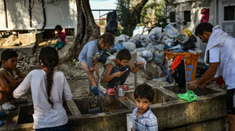 Refugees and migrants clean themselves at Moria camp