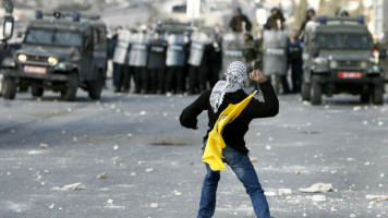 Palestinian youth throwing stones at Israeli forces [AFP]