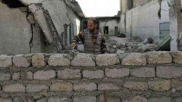 Syrian man rebuilding - AFP