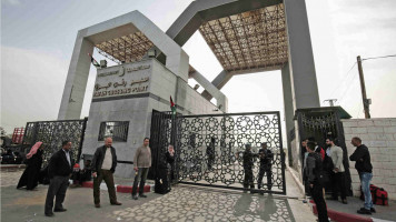 Palestinians wait to cross the Rafah border into Egypt