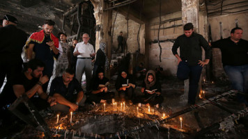 Iraqis light candles [AFP]