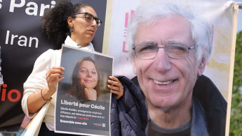 A supporter holds a placard bearing a portrait of French teacher Cecile Kohler, detained along with her partner Jacques Paris in Iran, during a rally in their support in Paris on May 14, 2023. (Photo by THOMAS SAMSON/AFP via Getty Images)