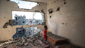 A Palestinian girl stands amid the rubble of her destroyed home on 24 May 2021 in Beit Hanoun, Gaza. [Getty]