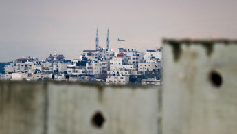 A picture shows the occupied West Bank village of al-Eizariya behind Israel's Apartheid wall on the outskirts of East Jerusalem [Getty Images]