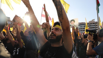 Supporters of Hezbollah leader Nasrallah watch as he makes his speech