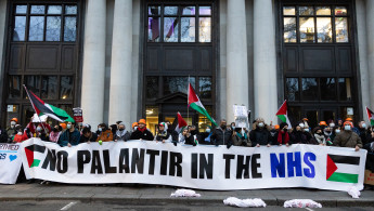 Protesters hold a banner reading: 'No Palantir in the NHS'