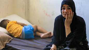 A child sleeps on a bed next to a woman, members of a family displaced by conflict from southern Lebanon taking refuge at a school turned into a temporary shelter in Beirut on September 24, 2024. (AFP via Getty Images)