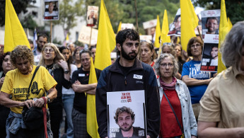 Demonstrators carrying Israeli flags and photos of hostages, gather in front of the Israeli Prime Minister's Office, on October 7, 2024 in Jerusalem.