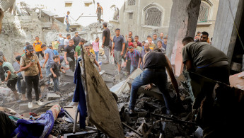 Palestinians gather amidst the rubble following an Israeli airstrike near the Jabalia Services Club in the northern Gaza Strip on October 5, 2024. 