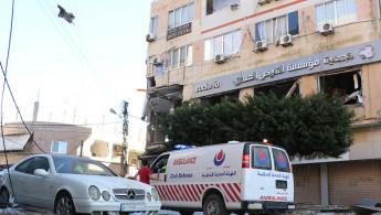 An ambulance arrives at the site of an overnight Israeli airstrike that targeted a branch of the Al-Qard Al-Hassan finance group in the southern city of Tyre on October 21, 2024. (Photo by BILAL KASHMAR/AFP via Getty Images)