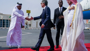 US Secretary of State Antony Blinken (C) is greeted by an official as US Ambassador to Qatar Timmy Davis (2R) and Qatari Ministry of Foreign Affairs Chief of Protocol Ibrahim Fakhroo (R) walk behind upon his arrival in Doha 