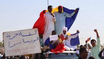 Protesters wave Chadian flags during an anti-France demonstration in N'djamena on December 6, 2024