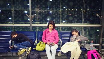 Mother and children relaxing in airport waiting area	