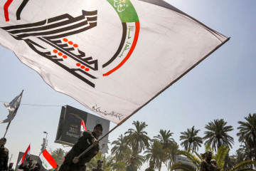 Members of Iraq's PMF march in a symbolic funerary parade in Baghdad on 29 June, 2021, in remembrance of those killed in a recent US raid. [Getty]