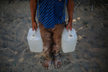 : Palestinian children collect drinking water - Getty