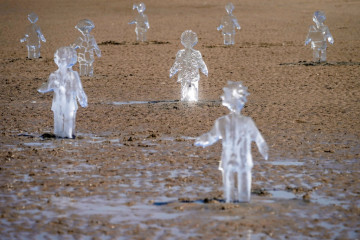 Some of 26 ice sculptures of children installed on New Brighton Beach begin to melt, as ice statues of children were installed as part of a giant sand artwork on New Brighton Beach to highlight global warming [Getty Images]