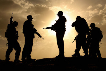 British soldiers from 21 Air Assault Battery Royal Artillery, who are providing the Helmand Task Force Provincial Reconstruction Team, are silhouetted against the sky as they provide security for a meeting with the Afghan National Police at the fortress Qala-e-Bost in Lashkar Gah, Helmand province.