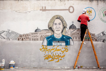 Palestinian artist paints a mural of Al-Jazeera journalist Shireen Abu Akleh in Khan Yunis in the southern Gaza Strip