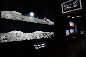 A picture taken on June 3, 2019, shows images of astronauts on the moon exhibited inside the Clock Tower Museum in the Saudi holy city of Mecca. - Overlooking the Kaaba, a black structure inside the Grand Mosque towards which Muslims around the world turn to pray, the four-storey Clock Tower Museum, opened a month ago. It is filled with models and structures on astronomy and galaxies, as Saudi authorities aim to lure more Muslim tourists to the country