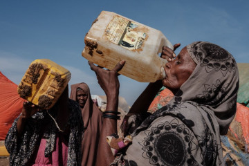 Hawa Mohamed Isack (R), 60, drinks water at a water distribution point at Muuri camp, one of the 500 camps for internally displaced persons (IDPs) in town, in Baidoa, Somalia