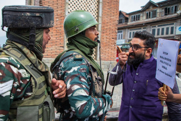 Indian paramilitary forces and Kashmiri men scuffle during a demonstration