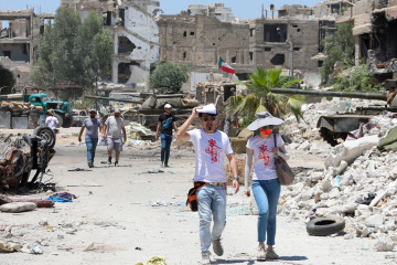 Actors are pictured in the Hajar al-Aswad neighbourhood of the Syrian capital Damascus on July 14, 2022, during the filming of a scene in a film titled "Home Operation", a Chinese-Emirati joint venture produced by actor Jackie Chan