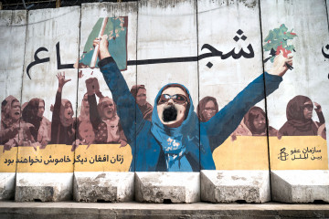 A wall mural of women with a writing "Afghan women will not be silent anymore" is depicted along a street in Kabul on January 10, 2023