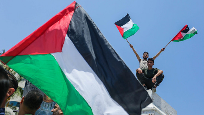 Palestinians protesters wave the Palestinian flags