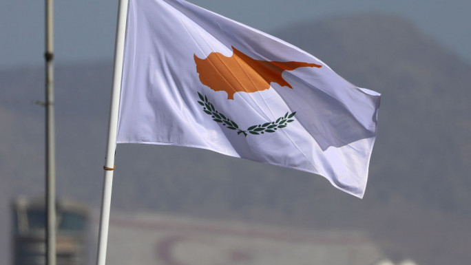 The national flag of Cyprus during a military parade celebrating the 61st anniversary of the Independence of Cyprus from British colonial rule, against background of Turkish Cypriot flag