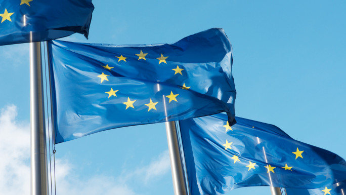 Four European Union flags waving in the wind