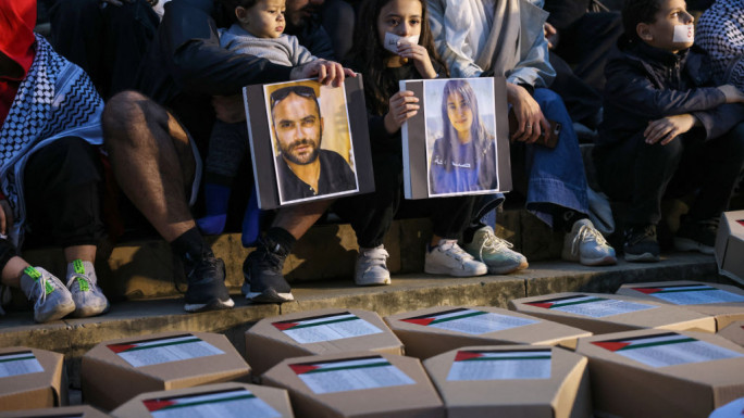 Demonstrators lift portraits of Reuters journalist Issam Abdallah (L) and Al-Mayadeen TV reporter Farah Omar, killed in separate instances while covering the frequent exchanges of fire across Lebanon's border with Israel